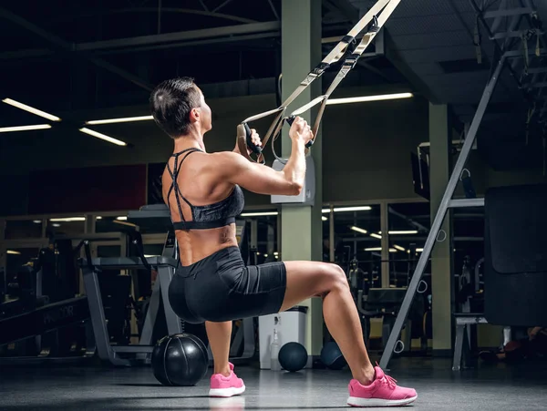 Frau macht Workouts mit Trx-Streifen — Stockfoto