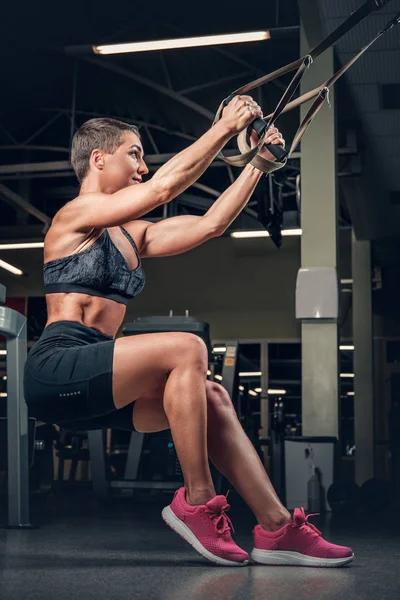 Frau macht Workouts mit Trx-Streifen — Stockfoto