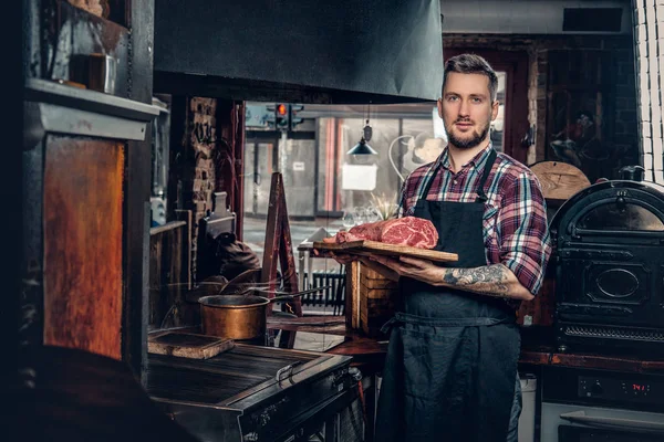 Knappe bebaarde chef-kok houdt biefstuk — Stockfoto