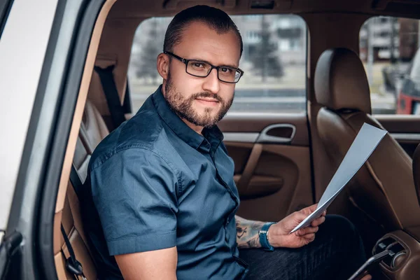 Homem de negócios barbudo em um banco traseiro de um carro — Fotografia de Stock