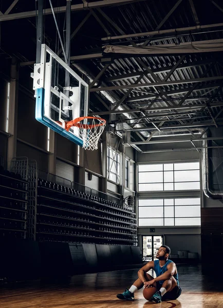 Jogador de basquete preto senta-se em um chão — Fotografia de Stock