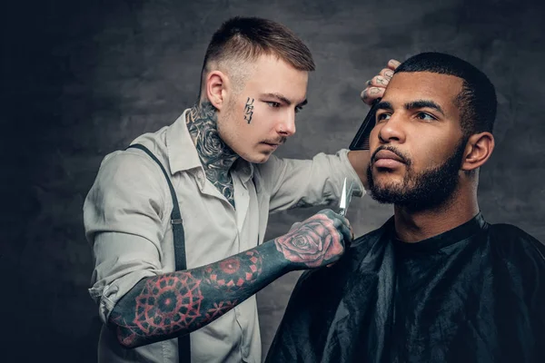 Tätowierter Friseur macht Haarschnitt — Stockfoto