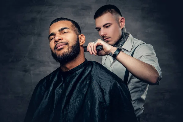 Tätowierter Friseur macht Haarschnitt — Stockfoto