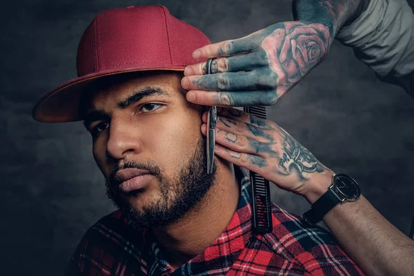 Tattooed barber cutting the beard — Stock Photo, Image