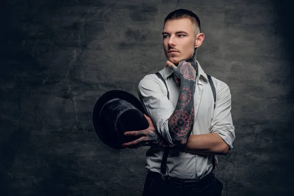 Татуированный мужчина в футболке и подтяжках — стоковое фото