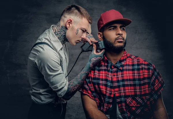 Tattooed barber cutting the beard — Stock Photo, Image