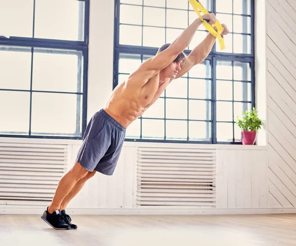 Мужчина упражняется с фитнес trx ремни — стоковое фото