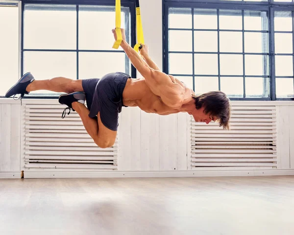 Uomo che si esercita con cinghie fitness trappole — Foto Stock