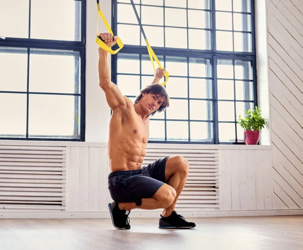 Uomo che si esercita con cinghie fitness trappole — Foto Stock