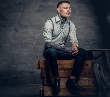 Yüzünde ve kolları dövmeli adam