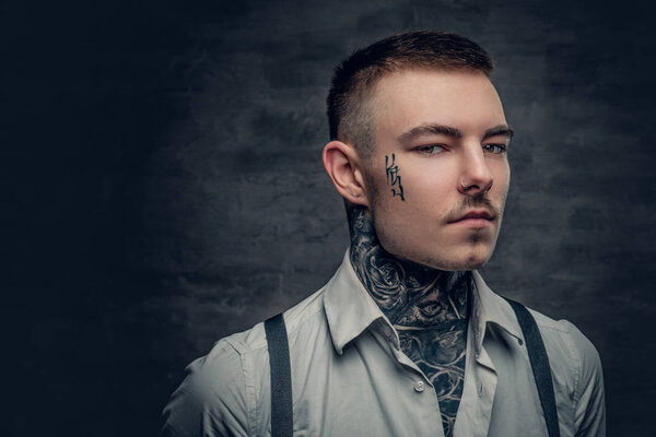 Татуированный мужчина в футболке и подтяжках
