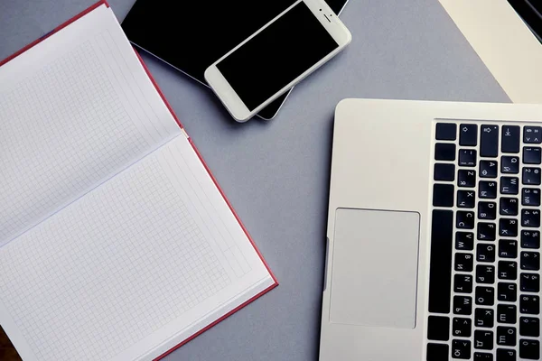 Paper notepad with smartphone and laptop — Stock Photo, Image