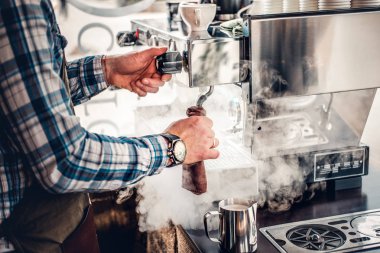 Adam bir kahve makinesi kapuçino hazırlanıyor