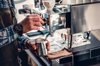 Adam bir kahve makinesi kapuçino hazırlanıyor