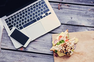 Dizüstü bilgisayar, akıllı telefon ve pita sandviç