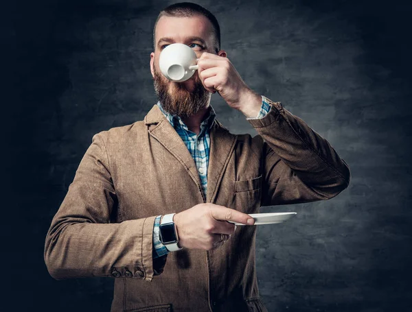 Bebaarde hipster mannelijke drinkt koffie. — Stockfoto