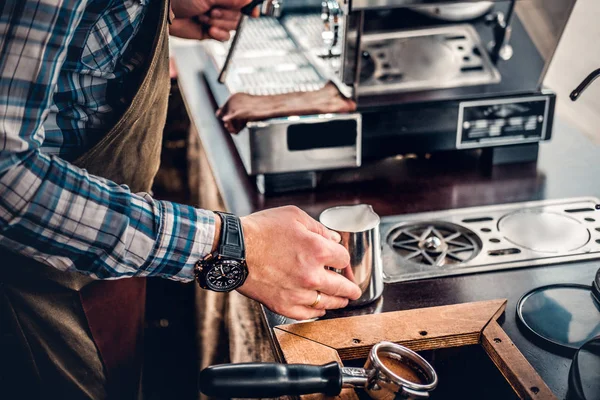 Человек готовит капучино в кофеварке — стоковое фото