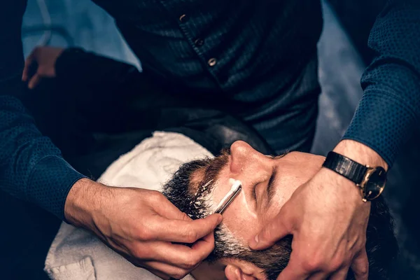 Keskin bir ustura ile tıraş sakallı erkek berber — Stok fotoğraf