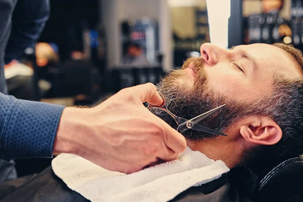 Peluquero corta la barba del hombre . —  Fotos de Stock