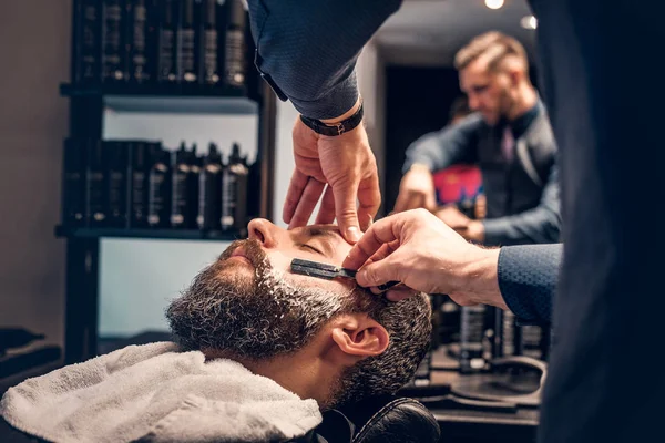 Peluquero afeitado barbudo macho con una navaja afilada —  Fotos de Stock