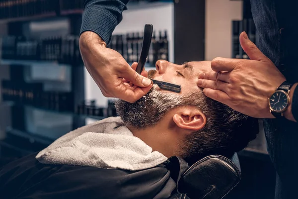 Barbier rasage mâle barbu avec un rasoir pointu — Photo