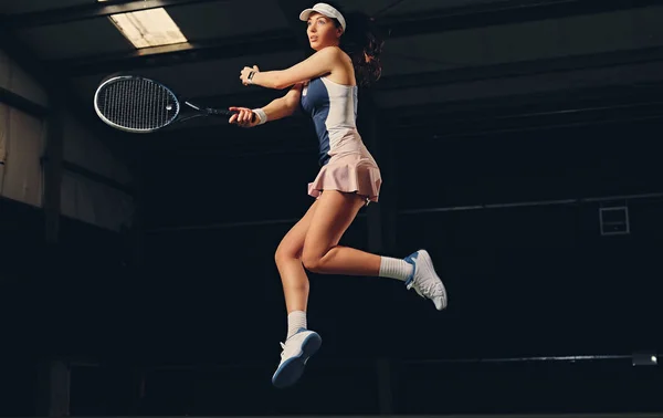 Jugadora de tenis femenina en un salto —  Fotos de Stock