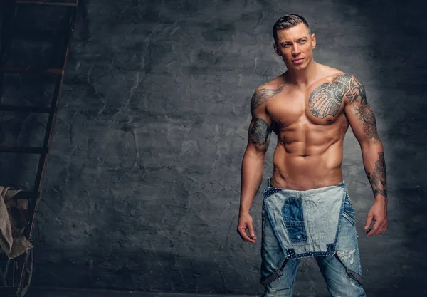 Muž s tetováním na sobě džíny — Stock fotografie