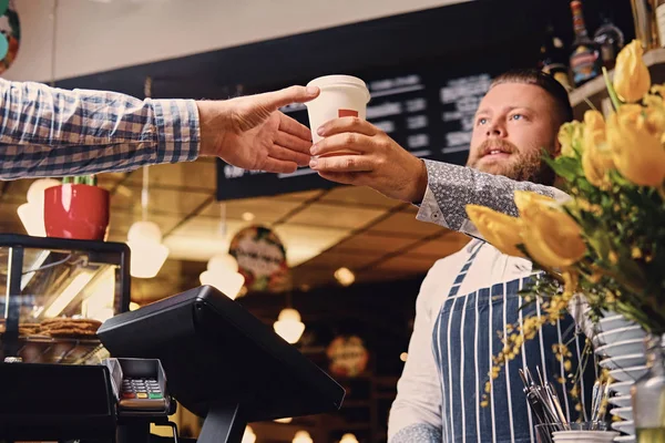 Bearded barista selling coffee to a consumer — Stock Photo, Image