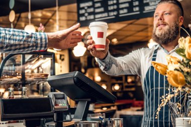 Sakallı barista kahve tüketiciye satış