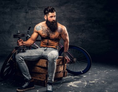 Gömleksiz sakallı adam dumbbell tutar