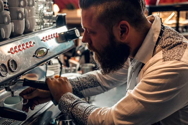 En skjeggete mann lager kaffe – stockfoto