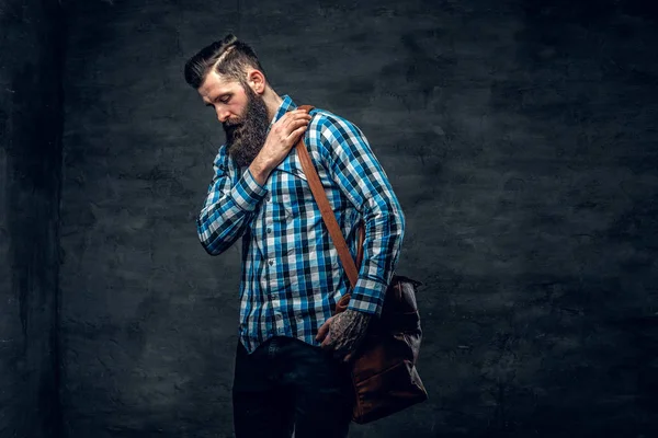 Bearded man holds backpack