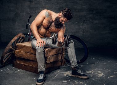 Gömleksiz adam dumbbell tutar