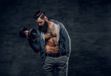 Atletik sakallı adam dumbbell tutar
