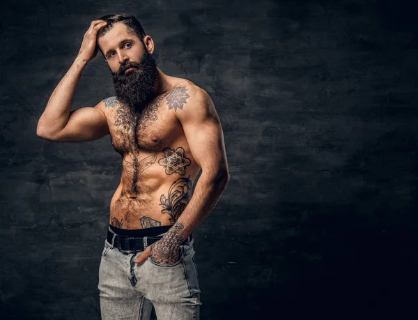 Shirtless bearded male with tattooed torso