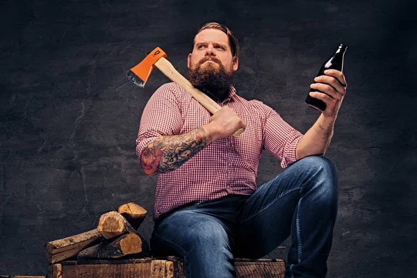 Lumberjack holds axe and beer bottle — Stock Photo, Image