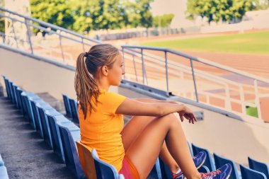 Sportif erkek stadyum koltuğu üzerinde oturur