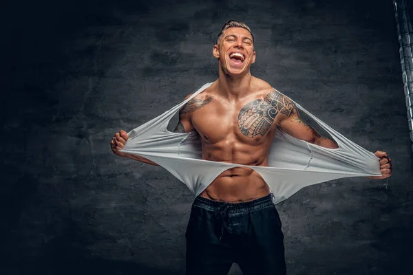 Uomo atletico strappando t shirt — Foto Stock
