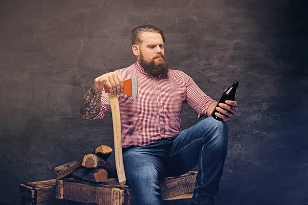 Ember tart egy üveg sört, és a fejsze — Stock Fotó