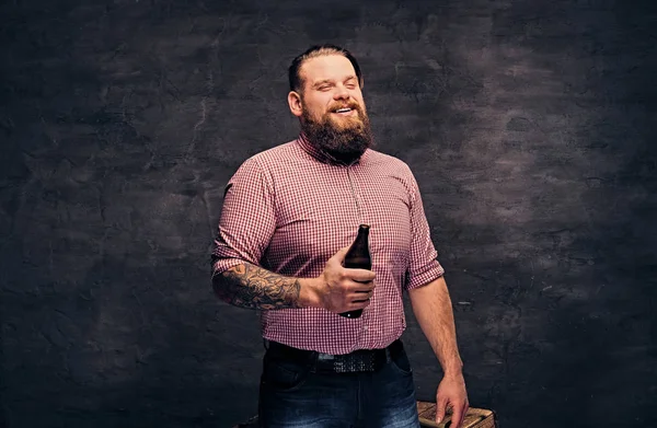 Bärtiger Mann hält eine Bierflasche in der Hand — Stockfoto