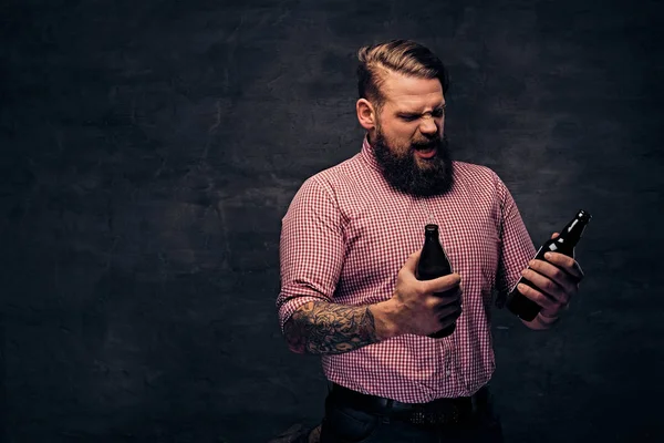 Bärtiger Mann hält eine Bierflasche in der Hand — Stockfoto