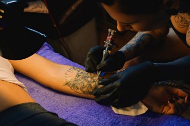 Bir kadının kolunda bir dövme yapma.