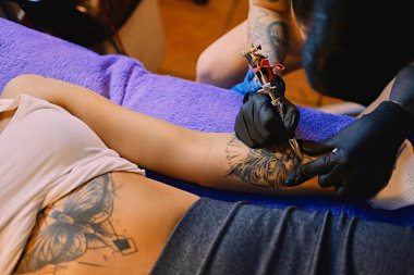 Bir kadının kolunda bir dövme yapma.