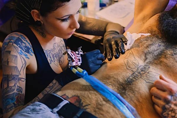 Femme tatoueuse fait un tatouage — Photo