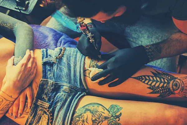 Tatuaje artista hace un tatuaje — Foto de Stock