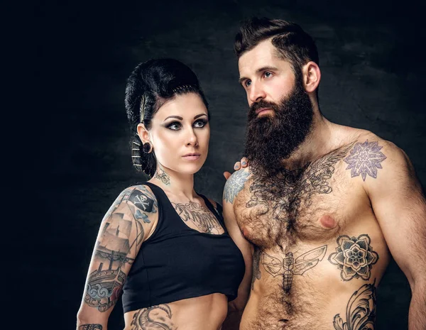 Studio portrait of tattooed couple