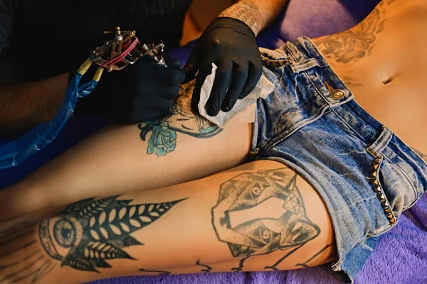 Making a tattoo on a woman's leg — Stock Photo, Image