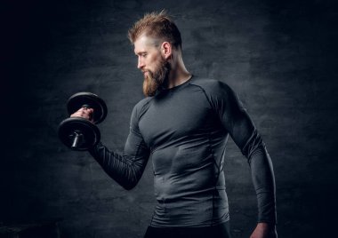 Sportif sakallı adam dumbbell tutar.