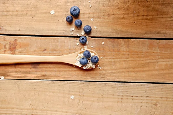 Cuchara de madera con copos de avena y arándanos — Foto de Stock