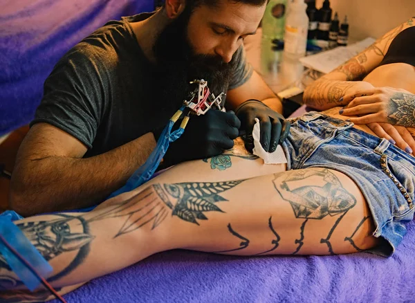 Tatuaje artista hace un tatuaje — Foto de Stock